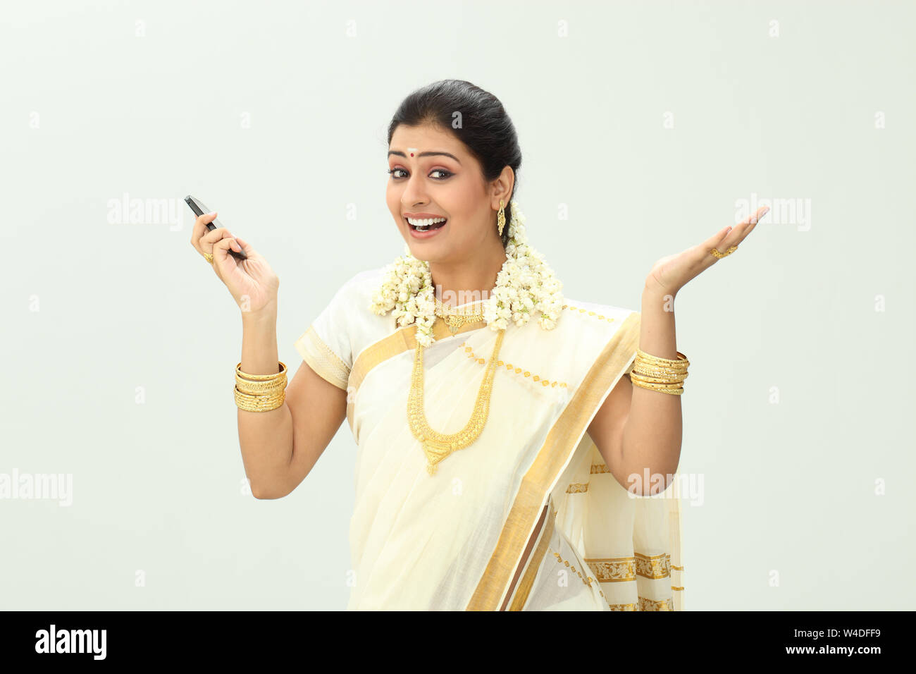 South Indian woman holding a mobile phone and gesturing Stock Photo - Alamy