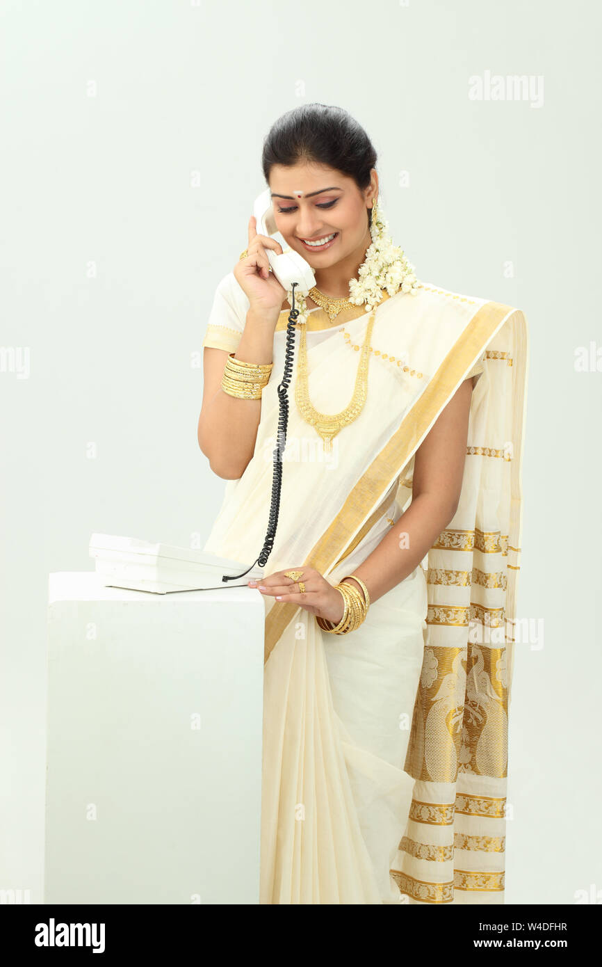 South Indian woman talking on landline phone and smiling Stock Photo ...