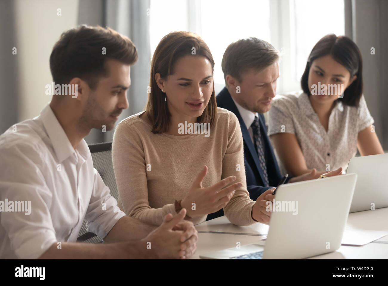 Female mentor help male intern explain online strategy on laptop Stock Photo
