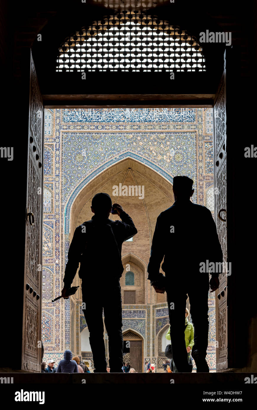 Silhouettes of visitors in front of Mir-i-Arab Madrasa (Mir Arab Madrasah), Bukhara, Uzbekistan Stock Photo