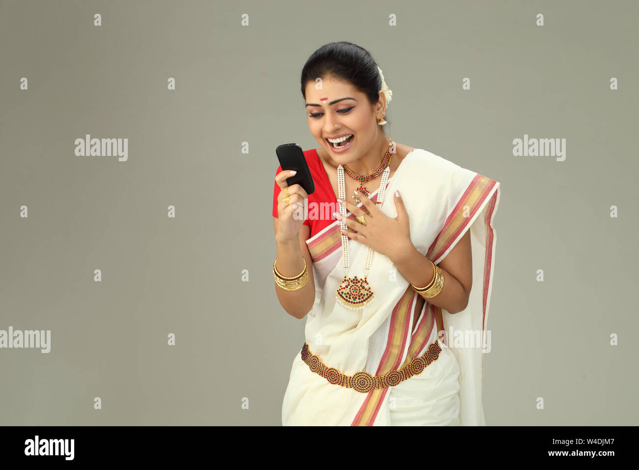 South Indian woman text messaging and smiling Stock Photo - Alamy