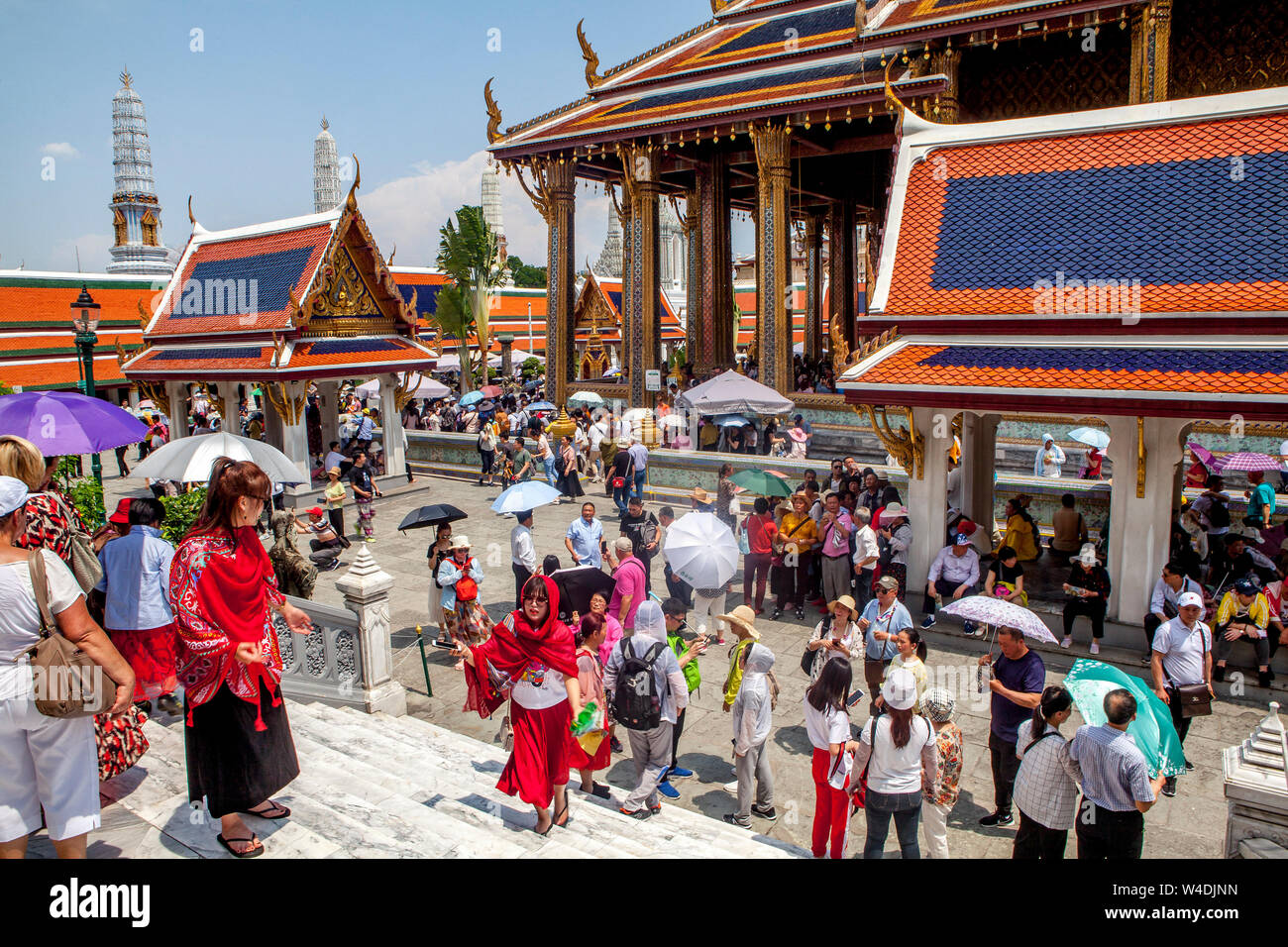 Thousands of tourists swarm the Wat Phra Kaew, Temple of the Emerald Buddha every day in Bangkok, Thailand. Stock Photo