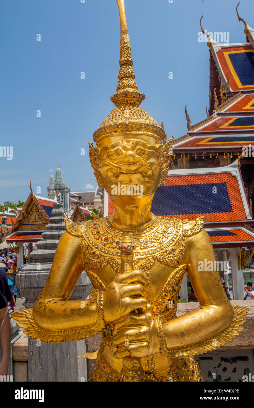 A mythological golden Yakshas guards the Temple of the Emerald Buddha at the Grand Palace in Bangkok, Thailand. Stock Photo