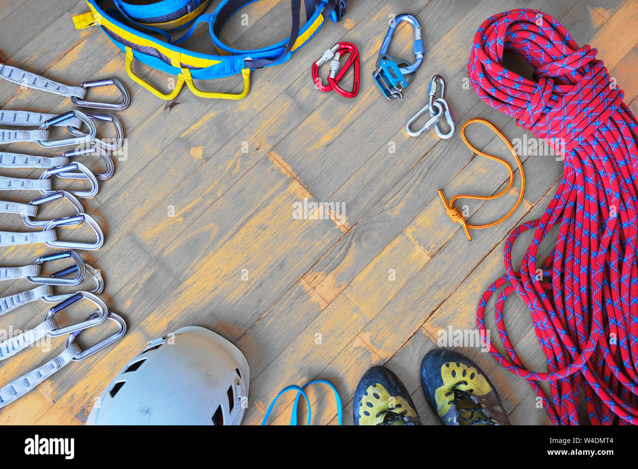 Sport climbing gear with space for text in the middle - top down view,  wooden background. Set of: quickdraws, helmet, harness, sling, shoes, rope,  pru Stock Photo - Alamy