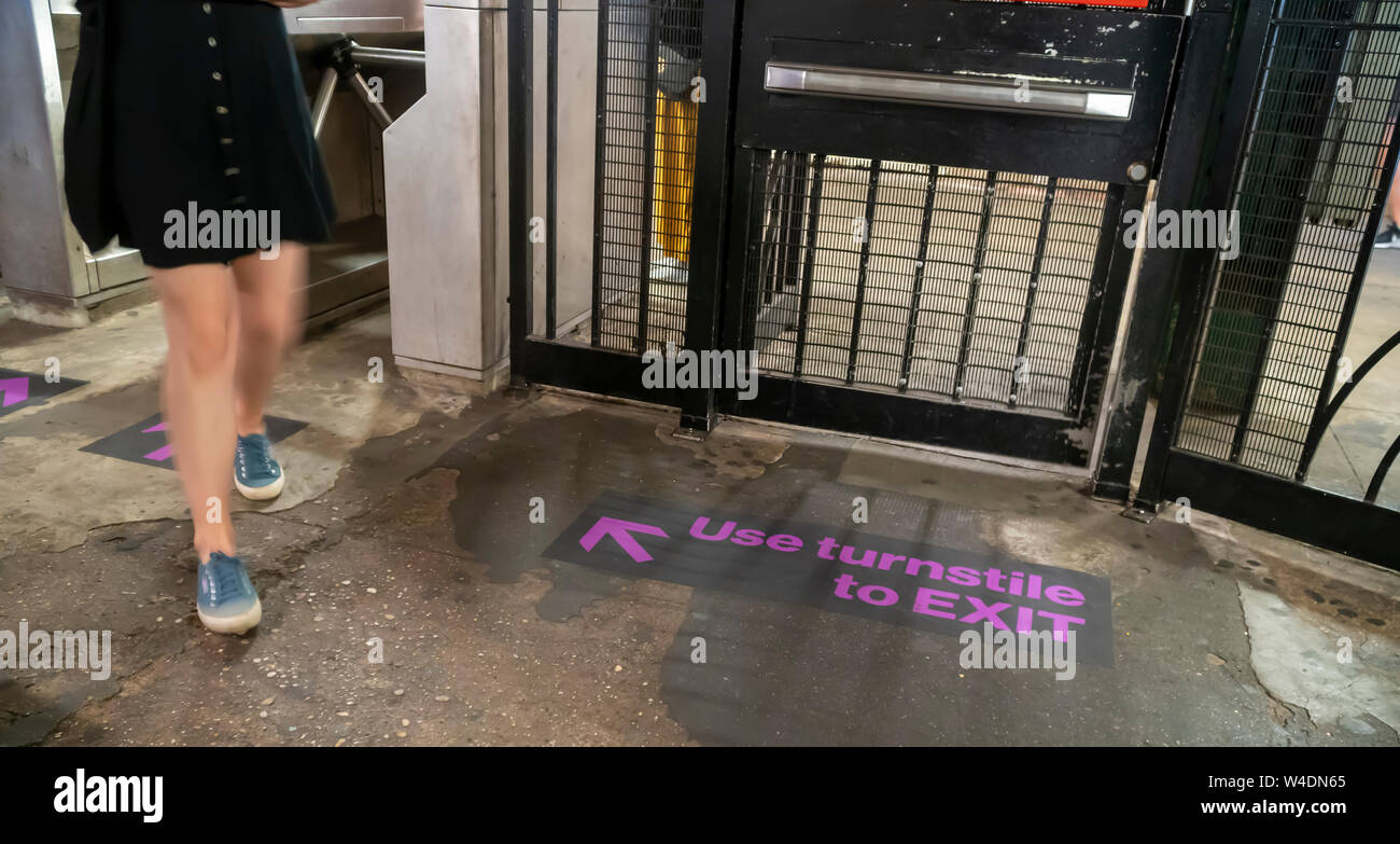 A decal in the West 4th street subway station in New York on Friday, July 19, 2019 directs commuters to use the turnstiles to exit and not the emergency gates. Fare evasion has been a drain on MTA revenue after the NYPD eased enforcement, issuing summonses as opposed to arrests, and the Manhattan District Attorney's office stopped prosecuting most cases. (© Richard B. Levine) Stock Photo