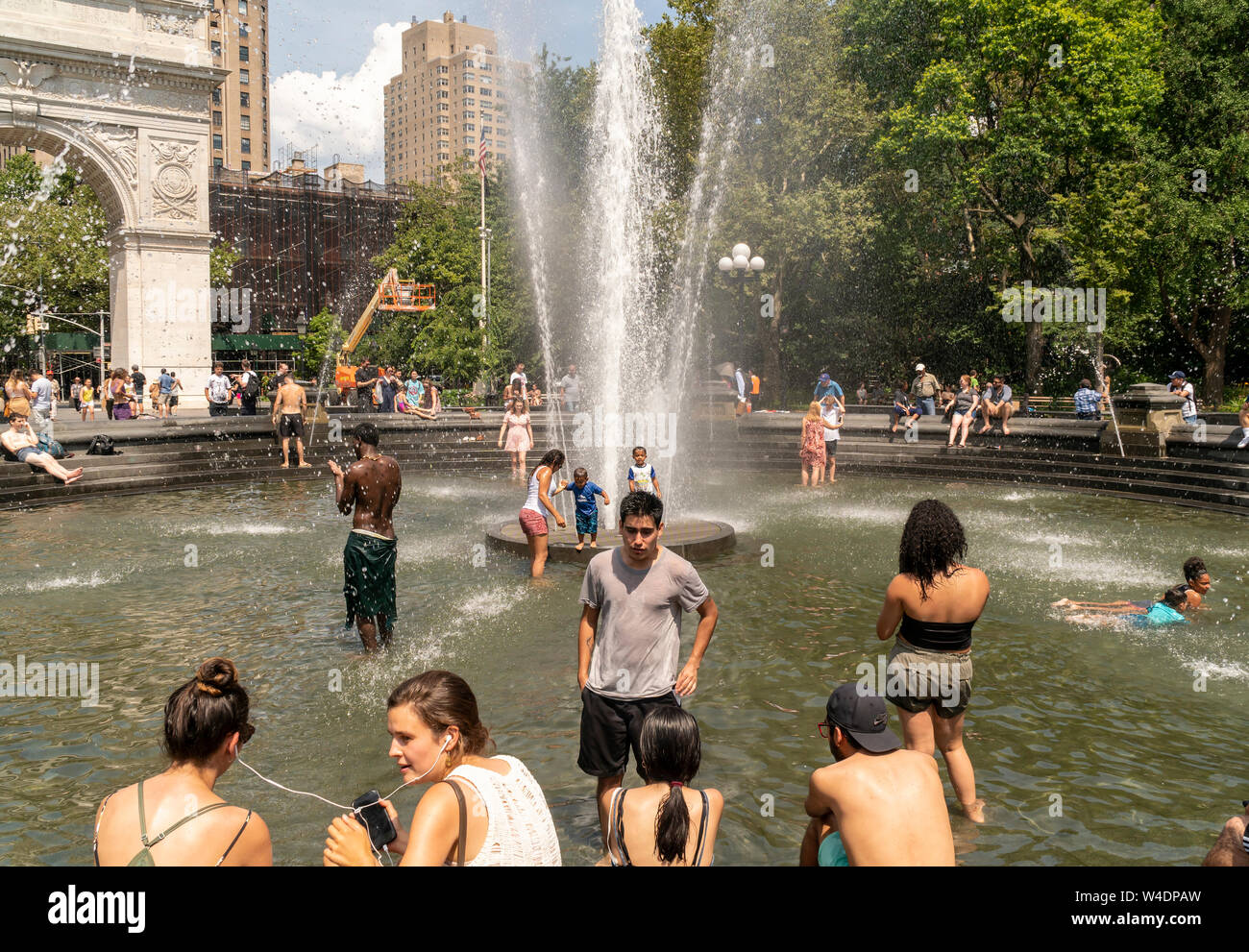 New Yorkers and visitors frolic by the fountain in Washington Square Park in Greenwich Village in New York on Saturday, July 20, 2019. An excessive heat warning is in effect in New York from noon Friday until 8PM Sunday as the oppressive combination of heat and humidity will make it feel like 105 degrees F. (© Richard B. Levine) Stock Photo