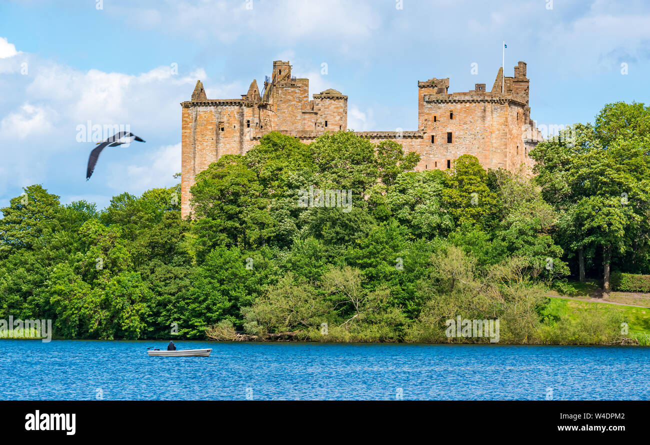 Linlithgow Loch and Linlithgow Palace, with fisherman in boat, Scotland, UK Stock Photo