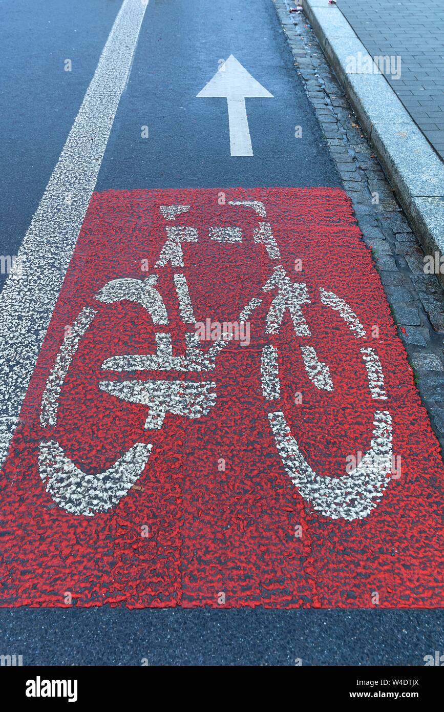 Red marked bicycle path on the roadway, Krakow, Poland Stock Photo