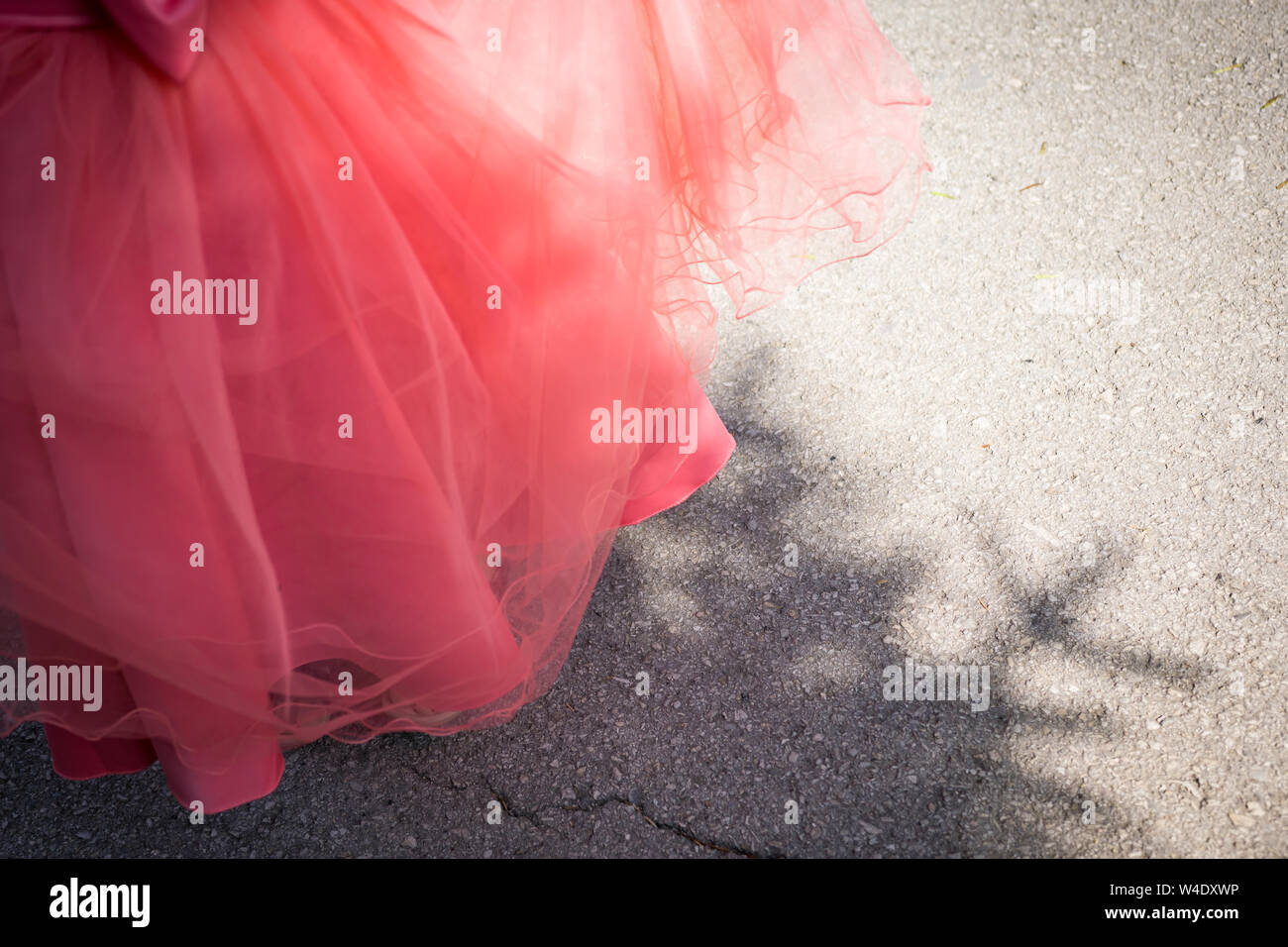Close-up of part of a little girl with a coral-dress princess dress. Shallow depth of focus. Stock Photo