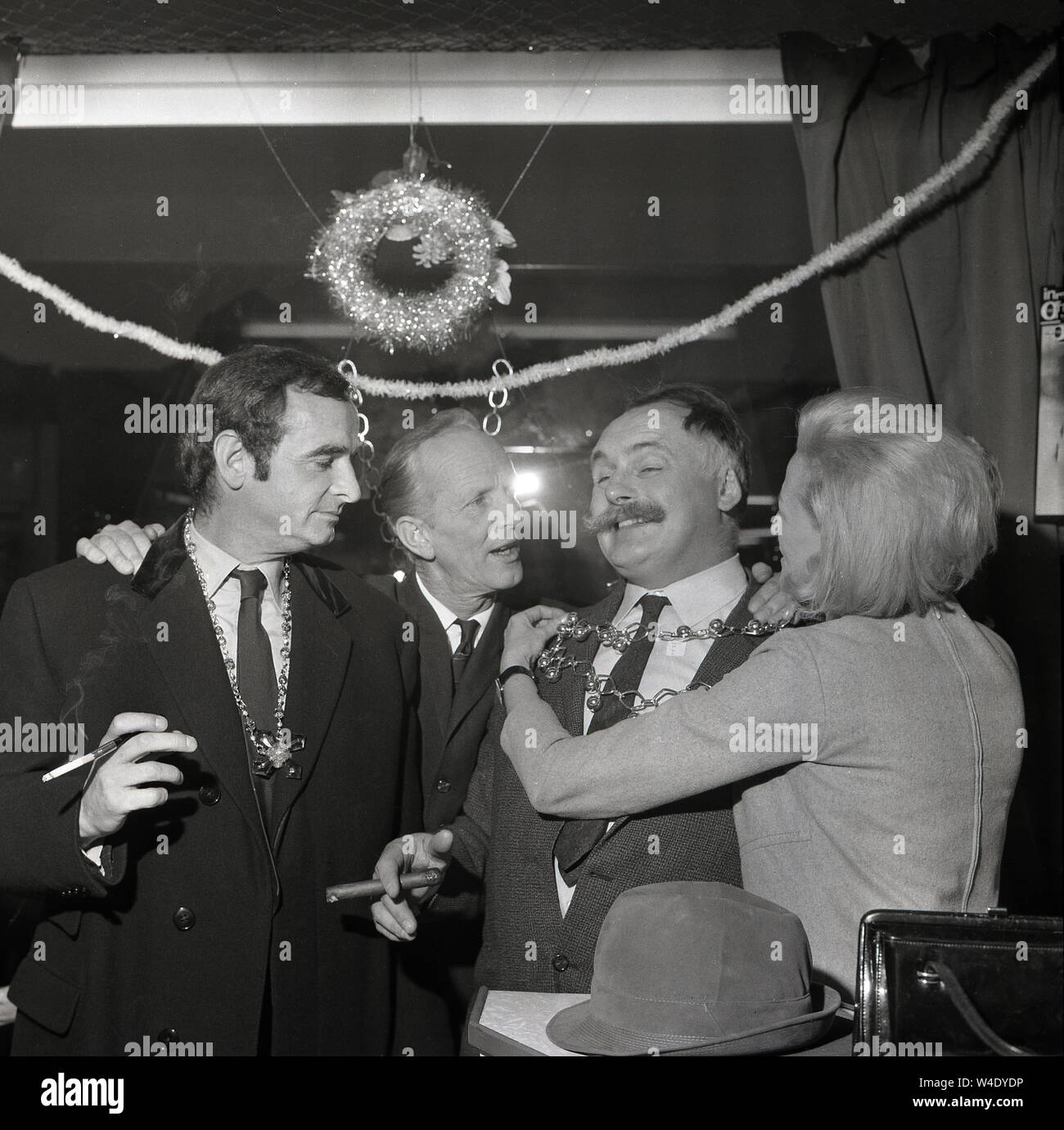 1960s, historical, comedy stars of the radio panel game, 'Does The Team  Think' seen here at a party with Jimmy Edwards, the creator the game on the  right, smoking a large cigar,