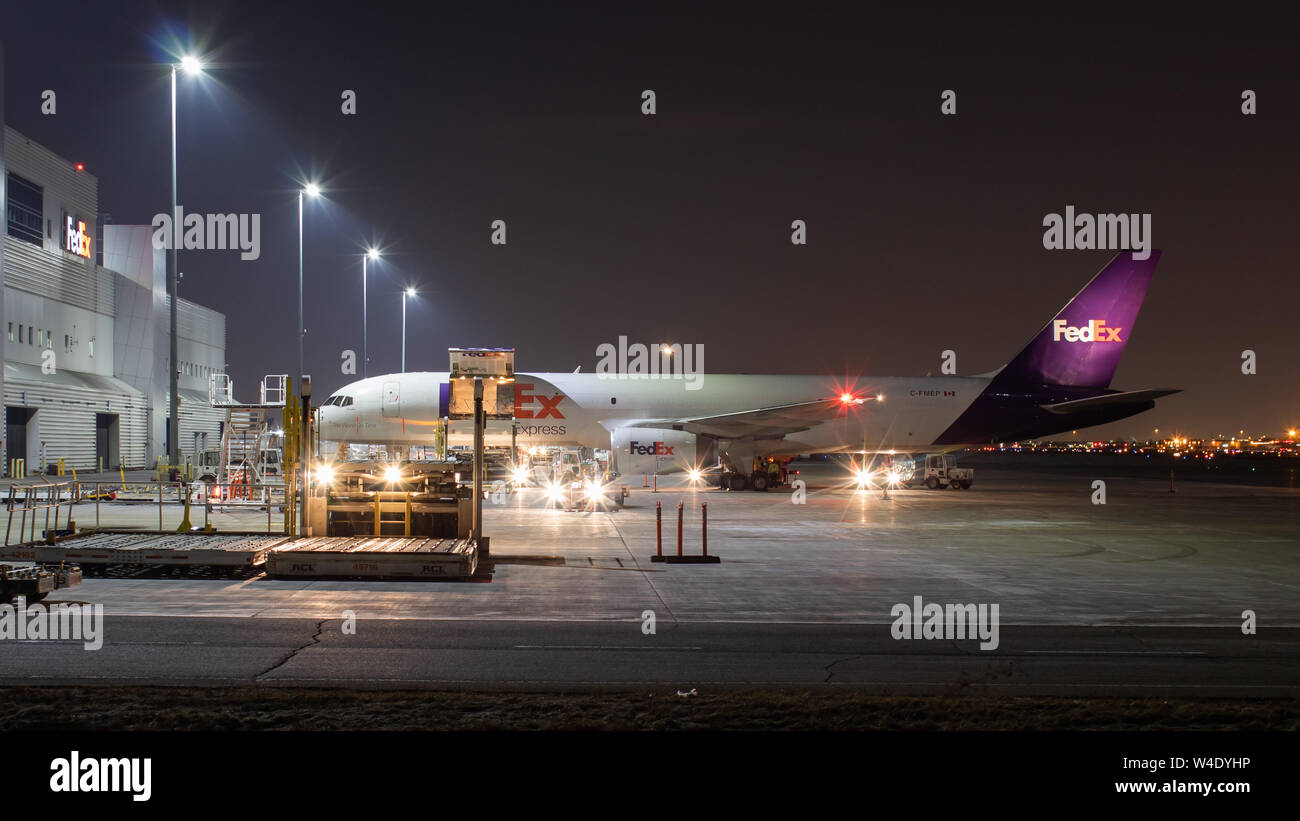 FedEx 757 at the FedEx Ship Centre at Toronto Pearson Intl. Airport being loaded for departure late at night. Stock Photo