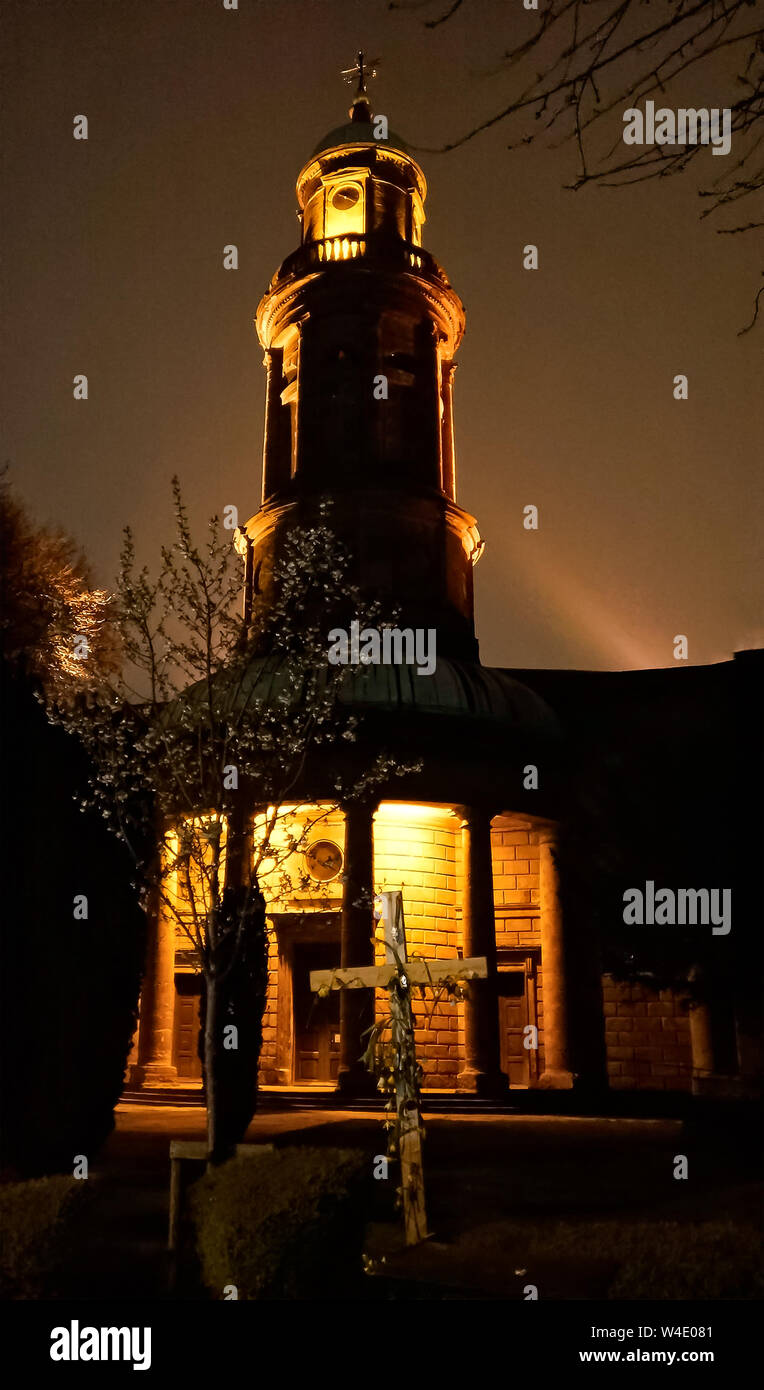 St Mary's Church, Banbury, Oxfordshire at night, and showing the floodlit pepper pot tower and the Easter Cross in the foreground. Stock Photo