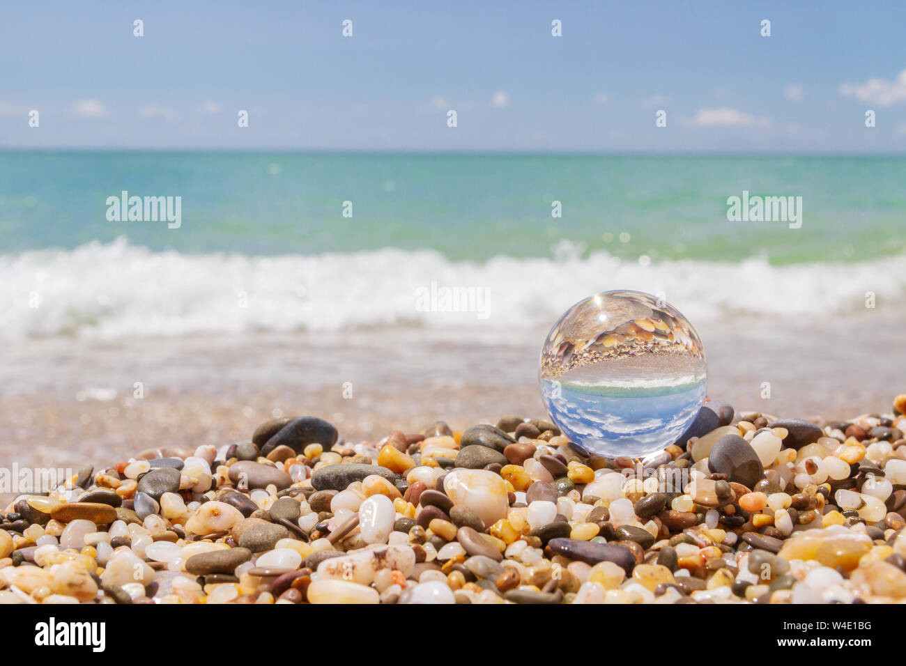 Glass round ball on the beach reflects the sea in summer Stock Photo ...