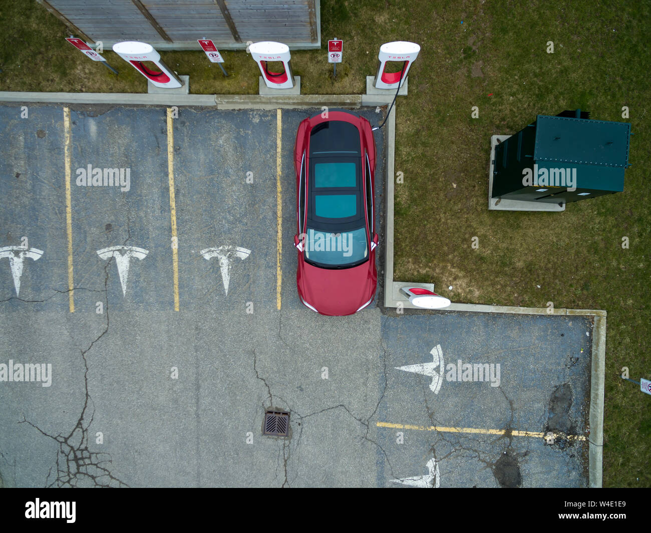 Aerial view of Tesla Supercharger in Woodstock, ON with Red Tesla Model S plugged-in, charging. Stock Photo