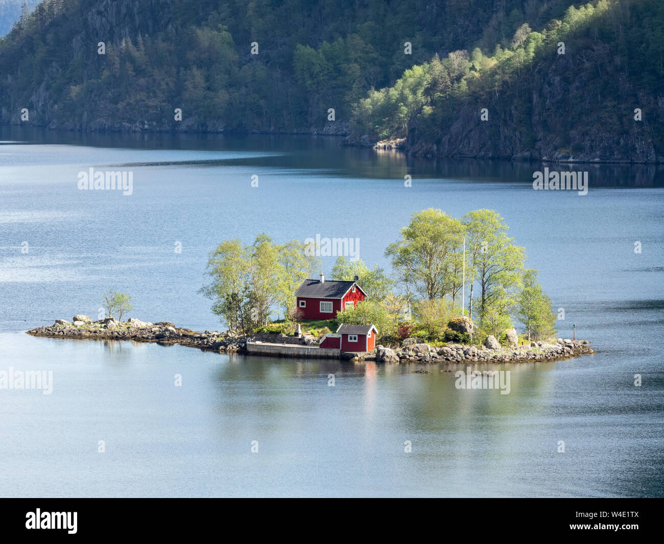 Typical red norwegian cottage on a little island in the fjord,  Lovrafjord, Norway Stock Photo