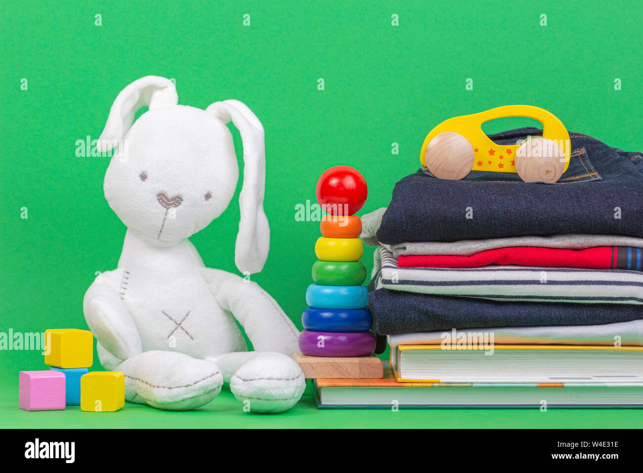 Donation concept. Kid toys, books and clothes for donate or charity on green background Stock Photo