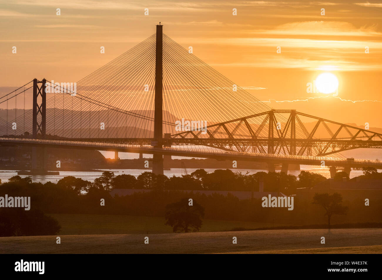 Queensferry Crossing at sunrise with the three Forth Bridges at South Queensferry Stock Photo