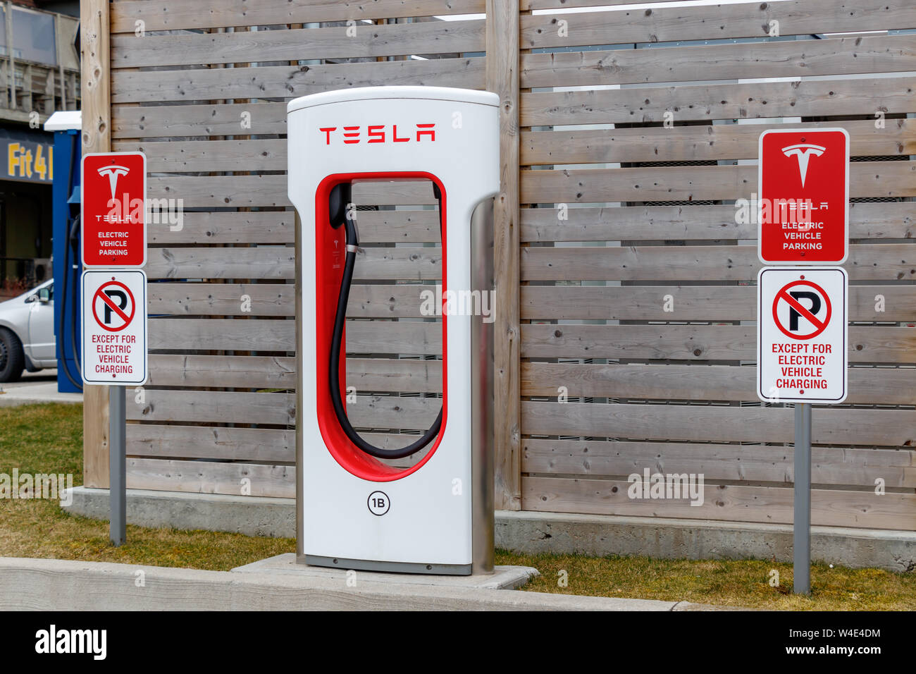 Tesla Supercharger Stall with information/restrictions signs beside. Stock Photo