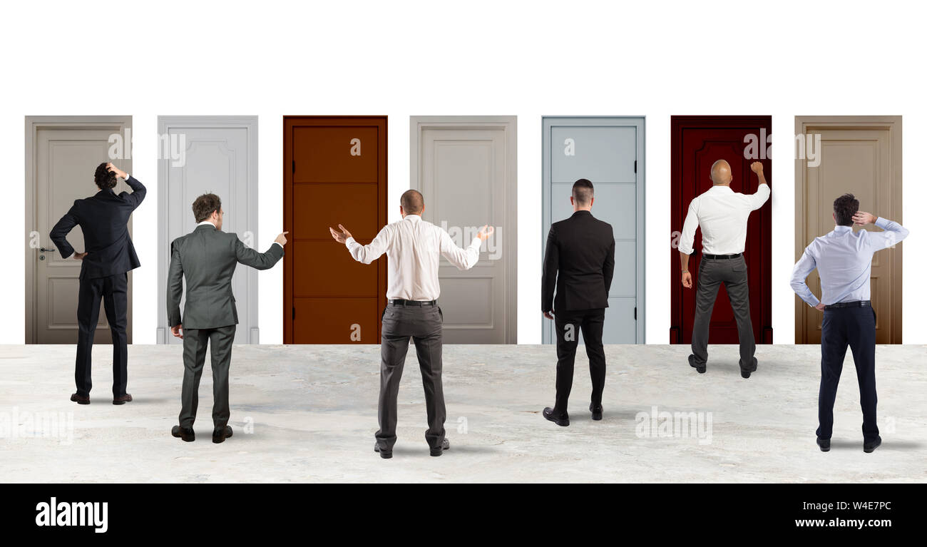 Business people looking to select the right door. Concept of confusion and competition Stock Photo