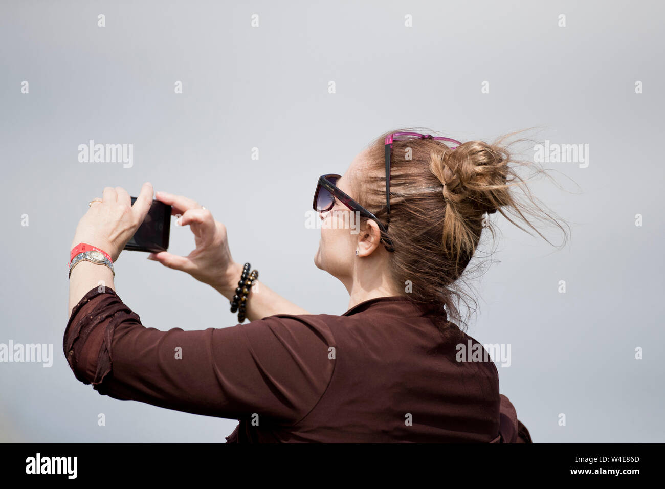Woman photographing an air display at RIAT air show, Fairford, Gloucestershire, uk Stock Photo