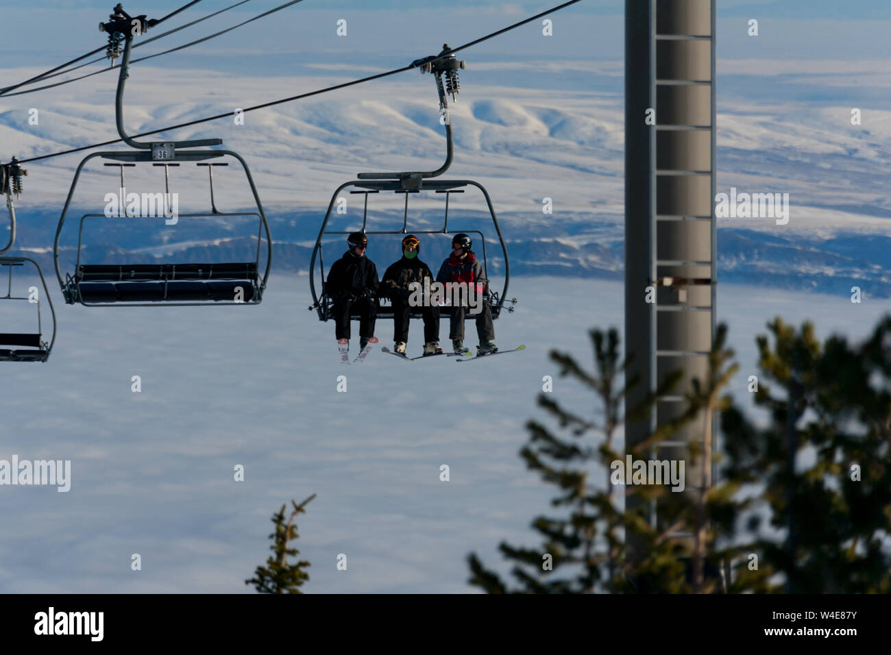 Skiers ride the Liberator quad chairlift to the mountain top on a cold