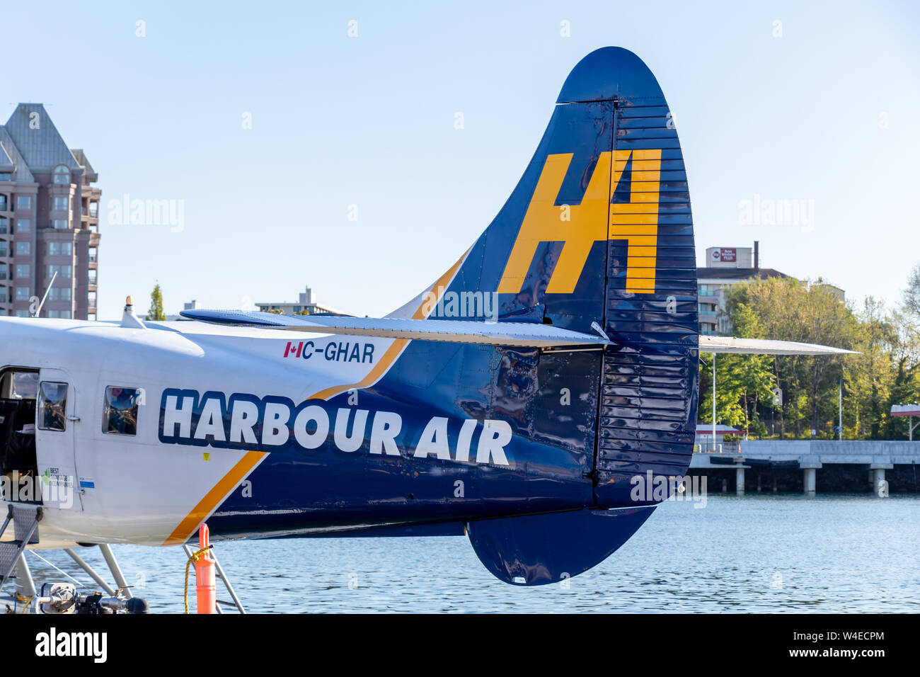 Harbour Air seaplane tail seen while docked at Victoria, BC's Harbour Airport in bright sunlight. Stock Photo