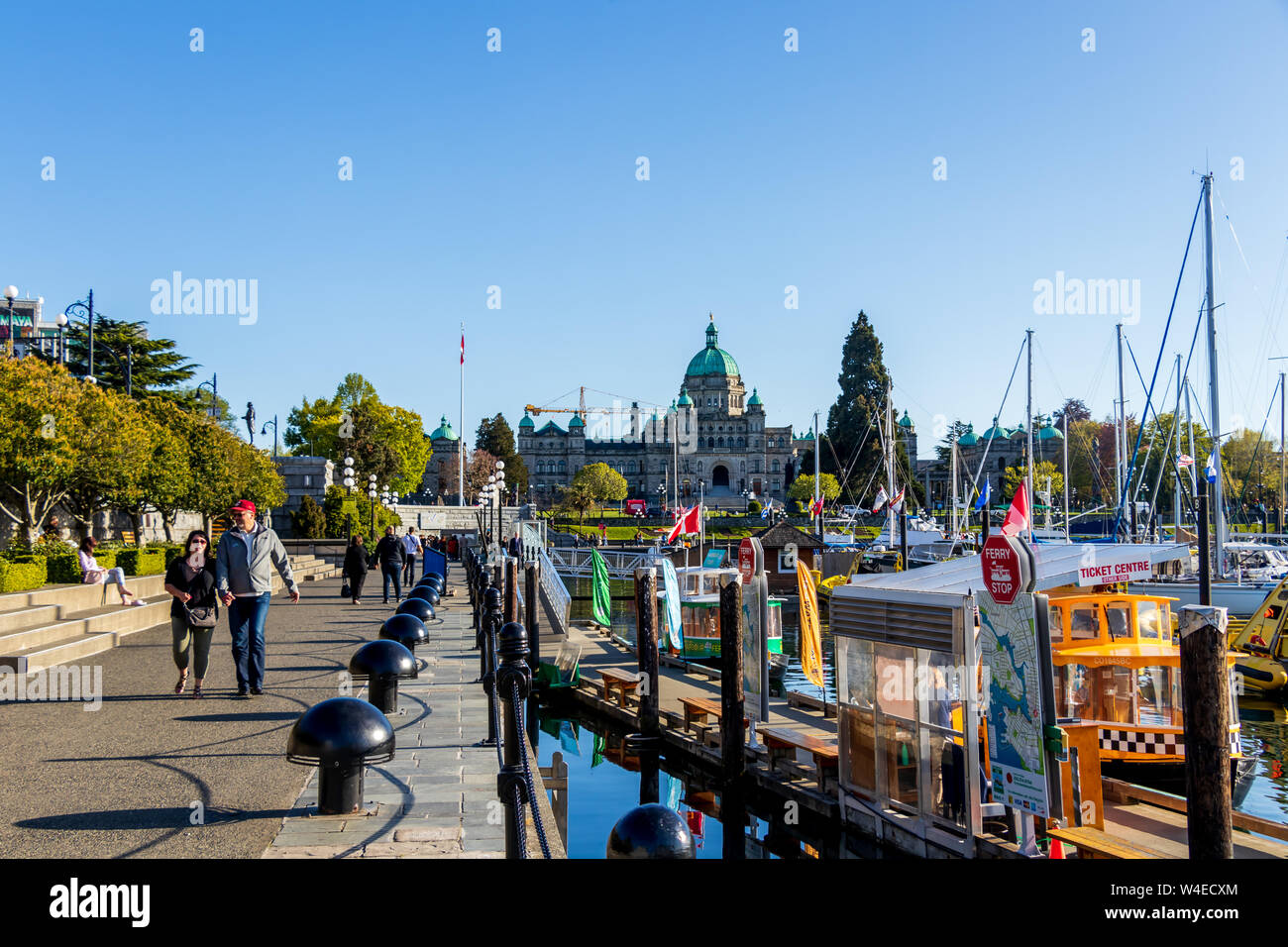 Legislative Assembly of British Columbia building seen from walkway alongside downtown boat marina in Victoria, BC. Stock Photo