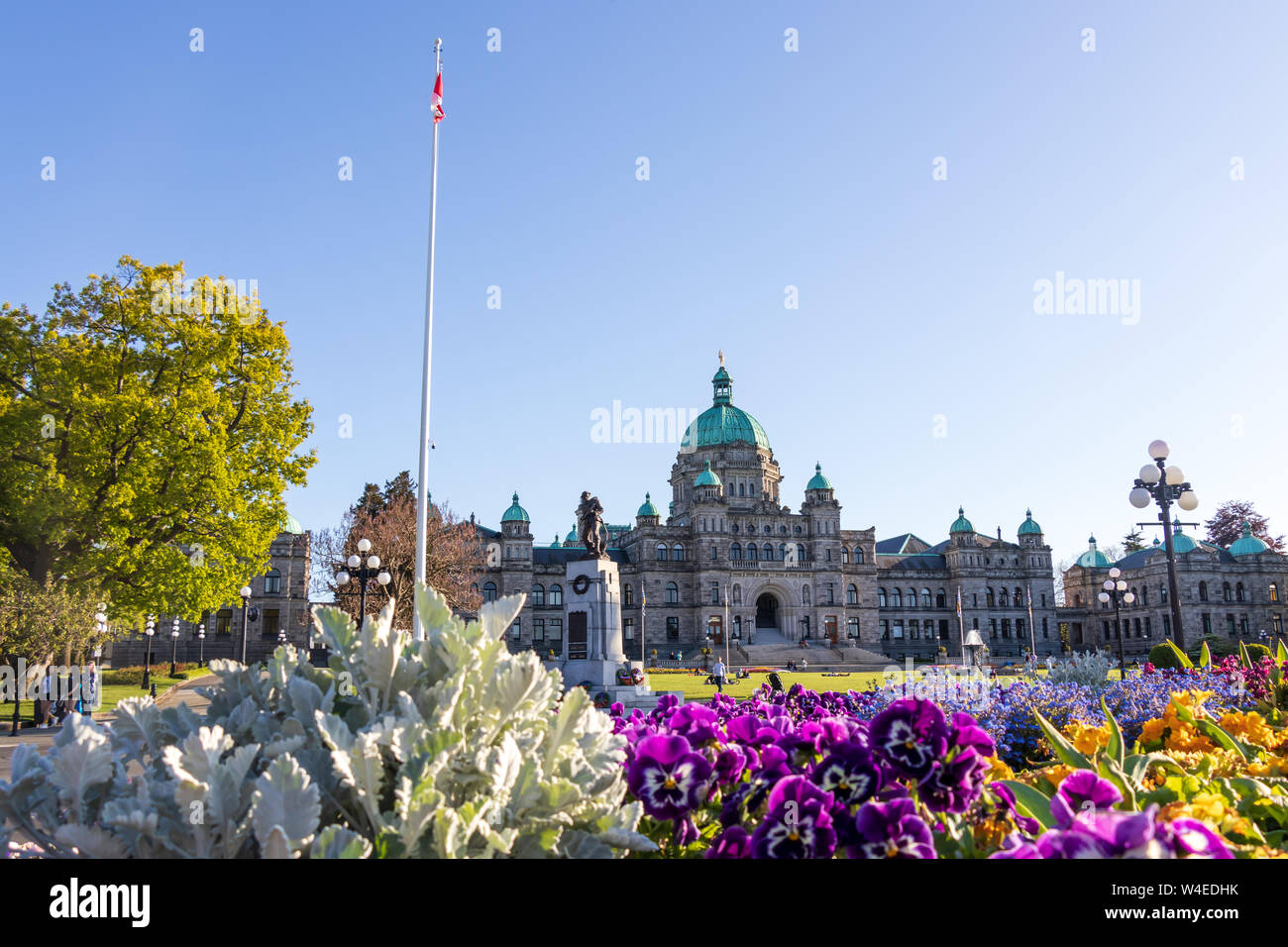 The Legislative Assembly of British Columbia seen behind a display of  beautiful, blooming spring flowers on a clear day. Stock Photo
