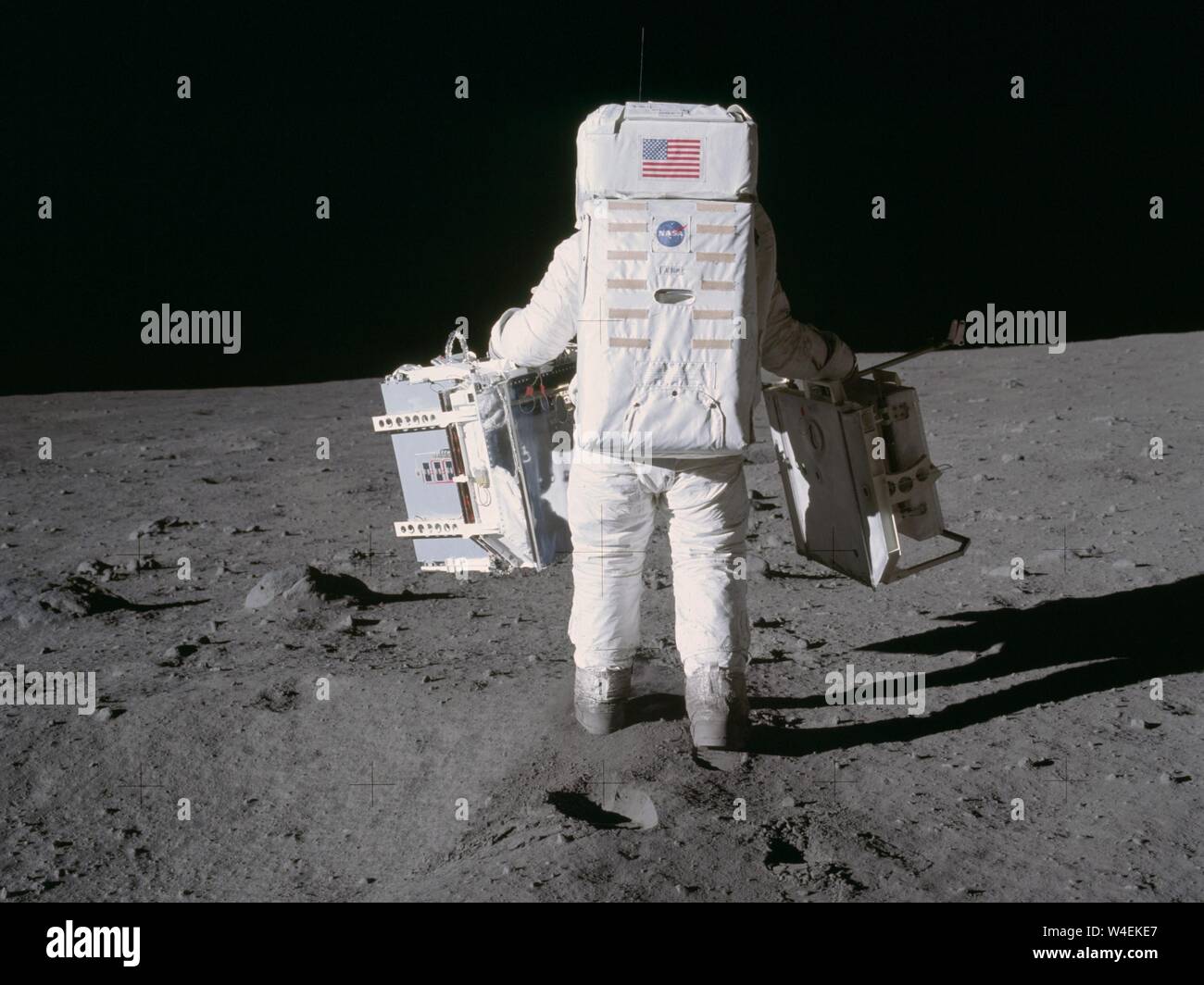 Astronaut and lunar module pilot Buzz Aldrin moves toward a position to deploy two components of the Early Apollo Scientific Experiments Package (EASEP) on the surface of the moon during the Apollo 11 extravehicular activity. The Passive Seismic Experiments Package (PSEP) is in his left hand; and in his right hand is the Laser Ranging Retro-Reflector (LR3). Mission commander Neil Armstrong took this photograph with a 70mm lunar surface camera. Image Credit: NASA/Capital Pictures  Credit NASA/Capital / MediaPunch  ** USA ONLY** Stock Photo