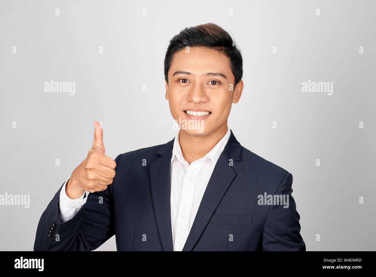 Asian smiling businessman showing thumb up one hand, isolated on white ...