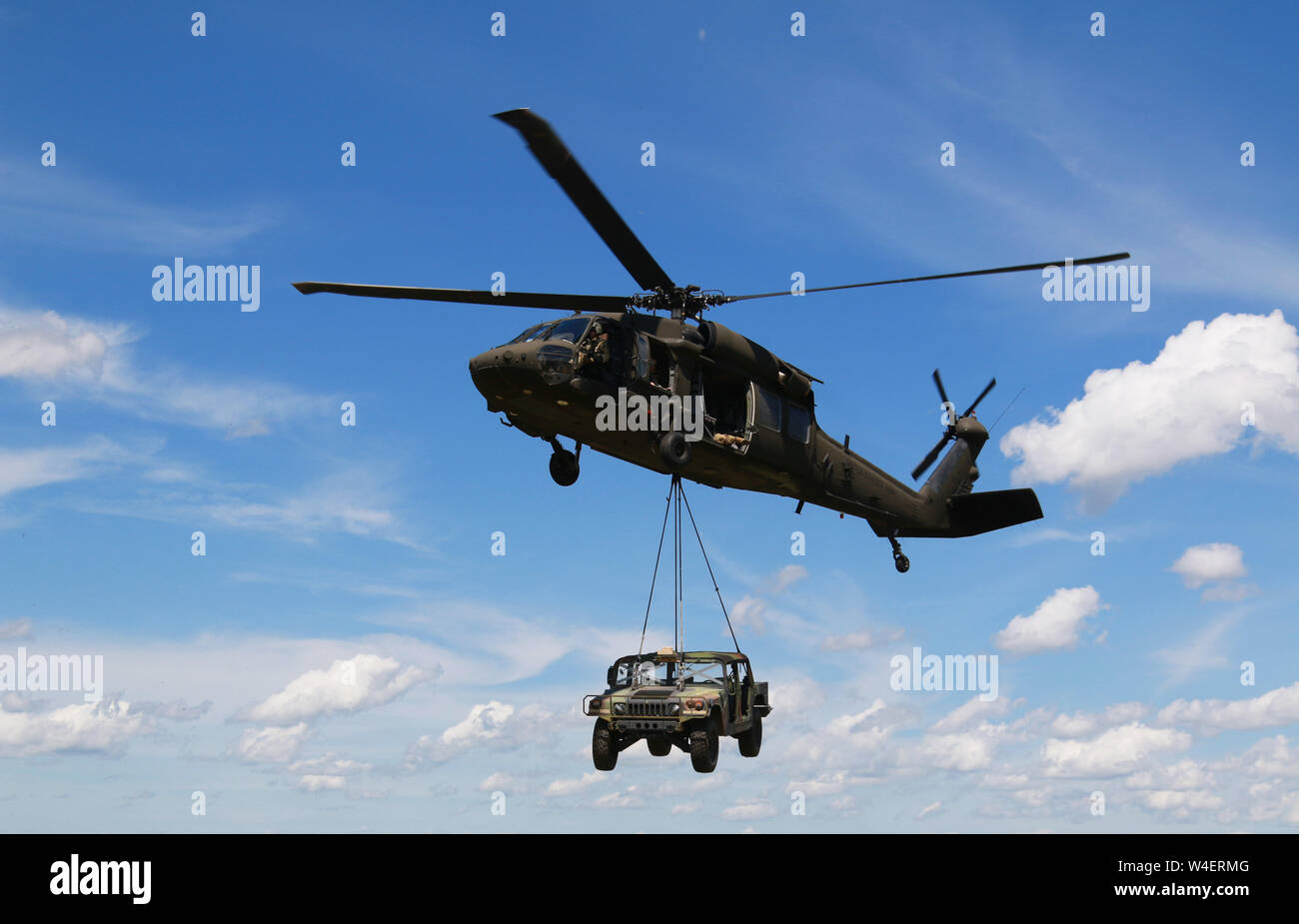 Members of Alpha Company, 1st of the 158th Assault Helicopter Battalion operate a UH-60 to perform sling load operations during Northern Strike 19 on Camp Grayling, Michigan, July 21, 2019. Northern Strike 19 is a National Guard Bureau-sponsored exercise uniting service member from more than 20 states, multiple service branches and numerous coalition countries during the last two weeks of July 2019 at the Camp Grayling Joint Maneuver Training Center and the Alpena Combat Readiness Training Center. (U.S. Army National Guard photo by Army Sgt. Priscilla Desormeaux/Released) (Photograph cropped t Stock Photo