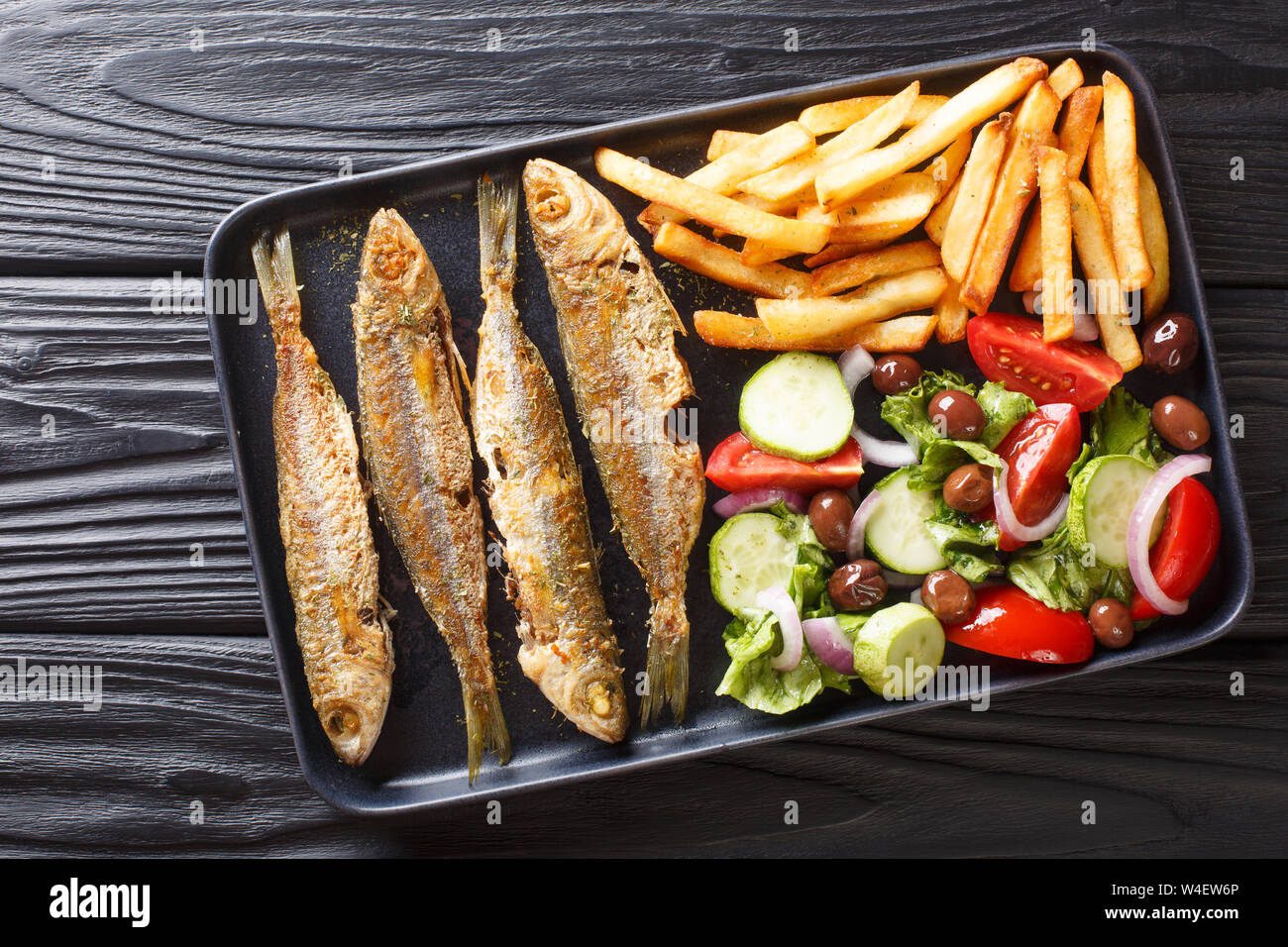 Fresh fried boops boops fish with summer vegetable salad and french fries close-up on a plate on the table. horizontal top view from above Stock Photo