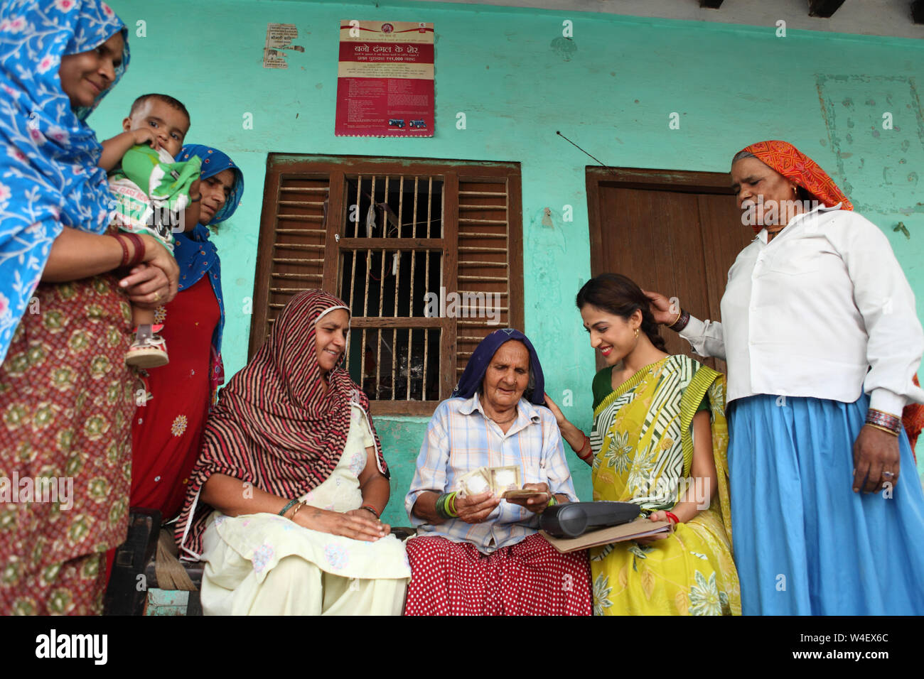 Female executive taking thumb impression of a rural woman on a money transfer machine Stock Photo