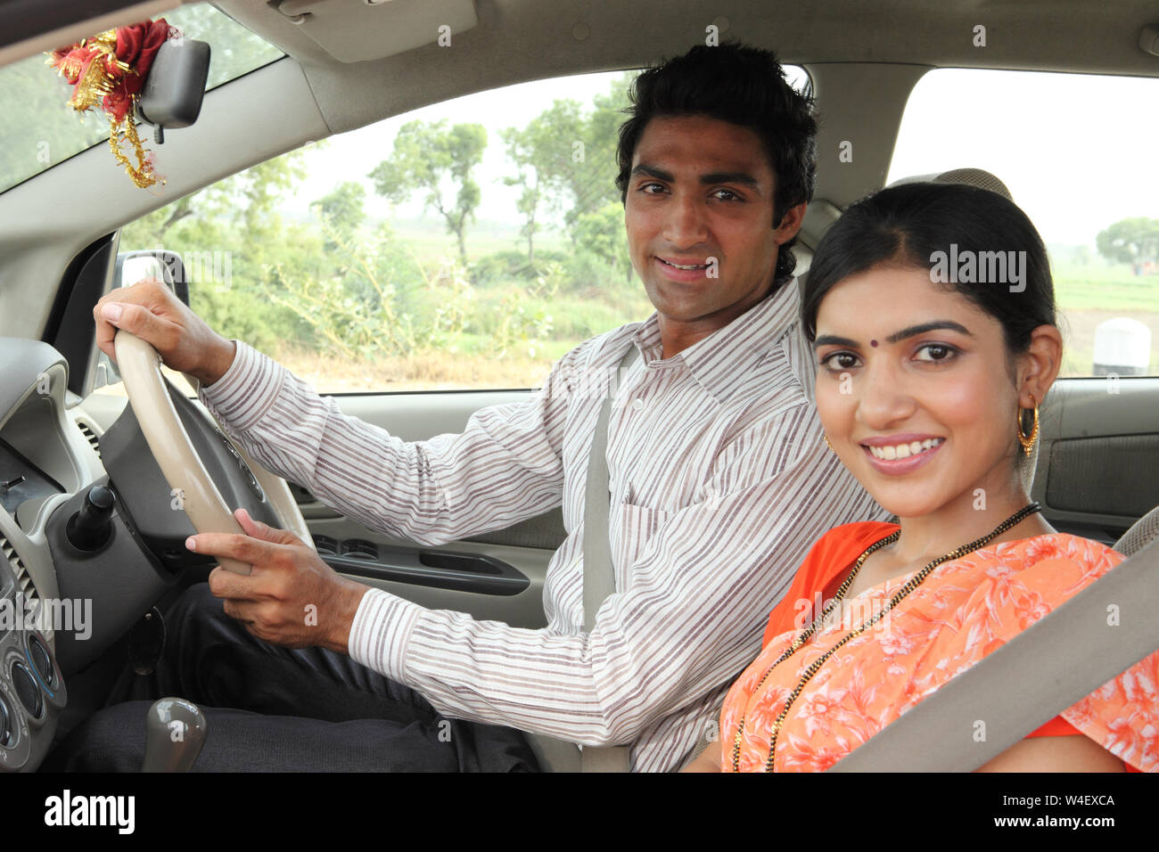 Man driving a car with his wife and smiling Stock Photo