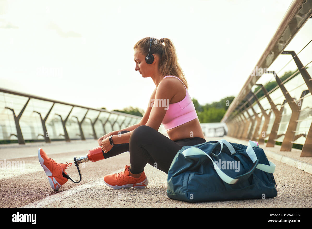 Young beautiful athletic woman with bionic prosthetic leg doing