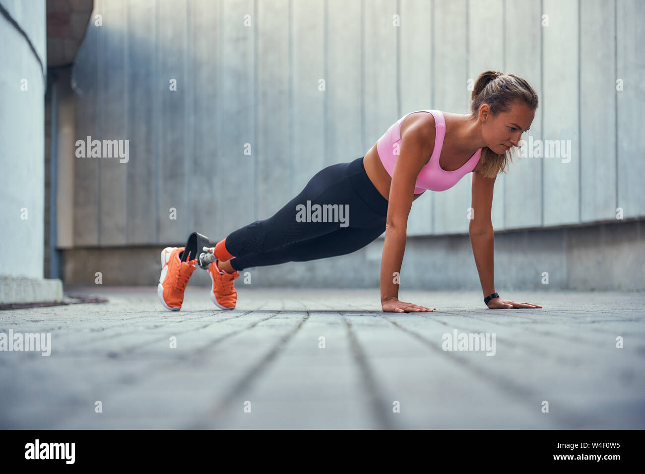 Perfect shape. Full-length of young woman with leg prosthesis in sportswear  doing plank exercise outdoors. Disabled sport concept. Motivation. Healthy  lifestyle Stock Photo - Alamy