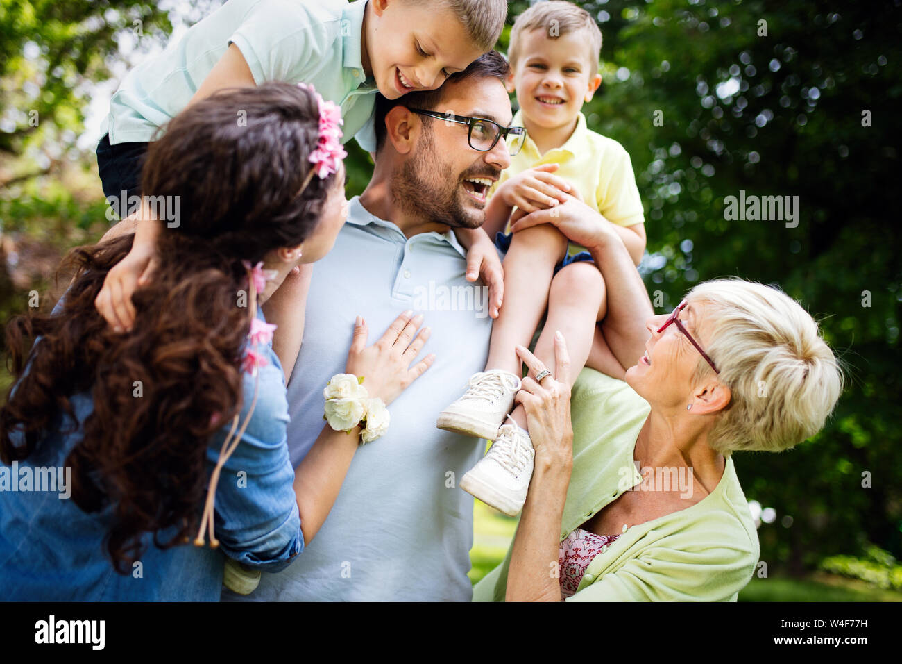 Happy young family playing on the grass in the park and enjoying picnic Stock Photo