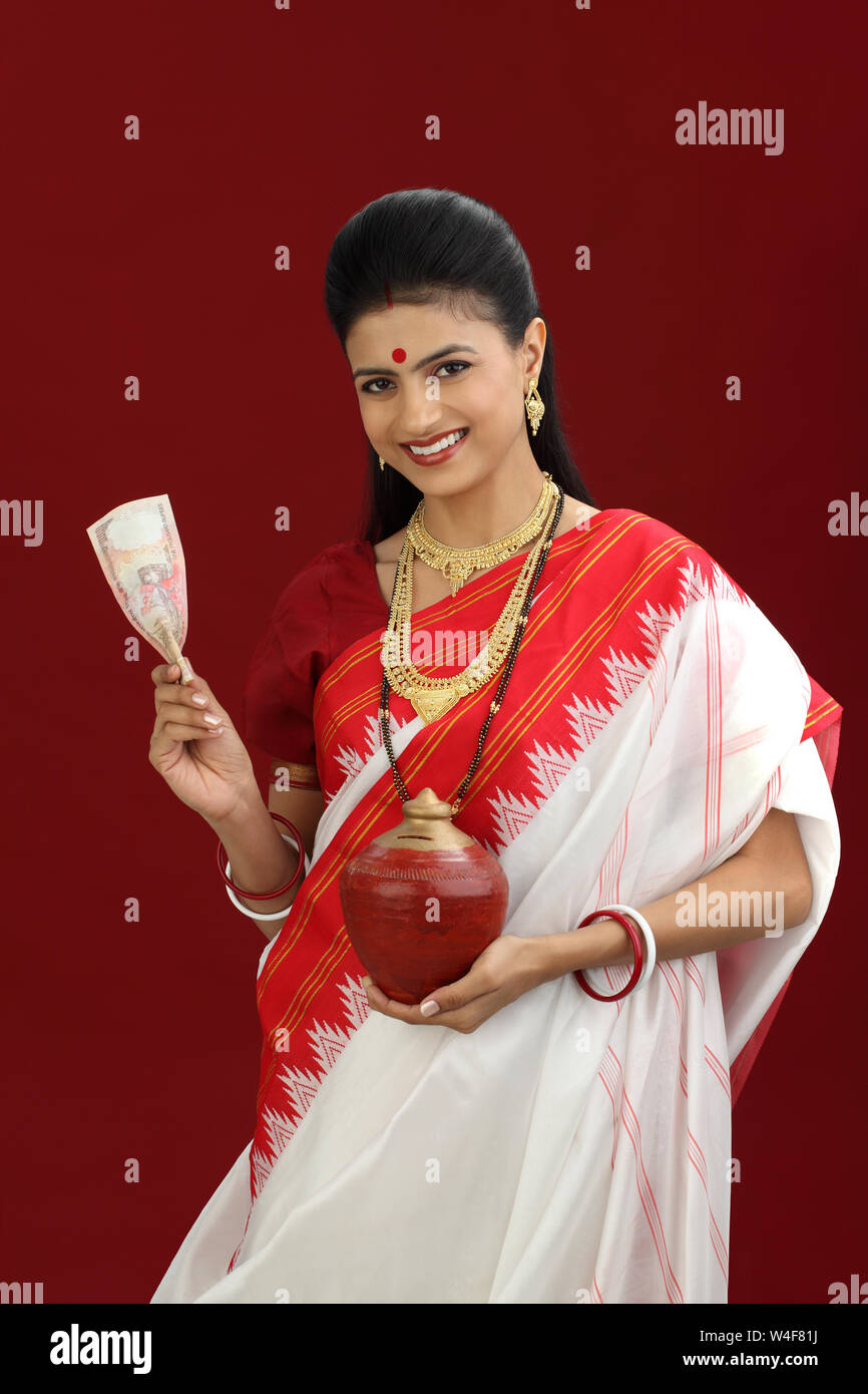 Bengali woman holding Indian banknote and a piggy bank Stock Photo Alamy