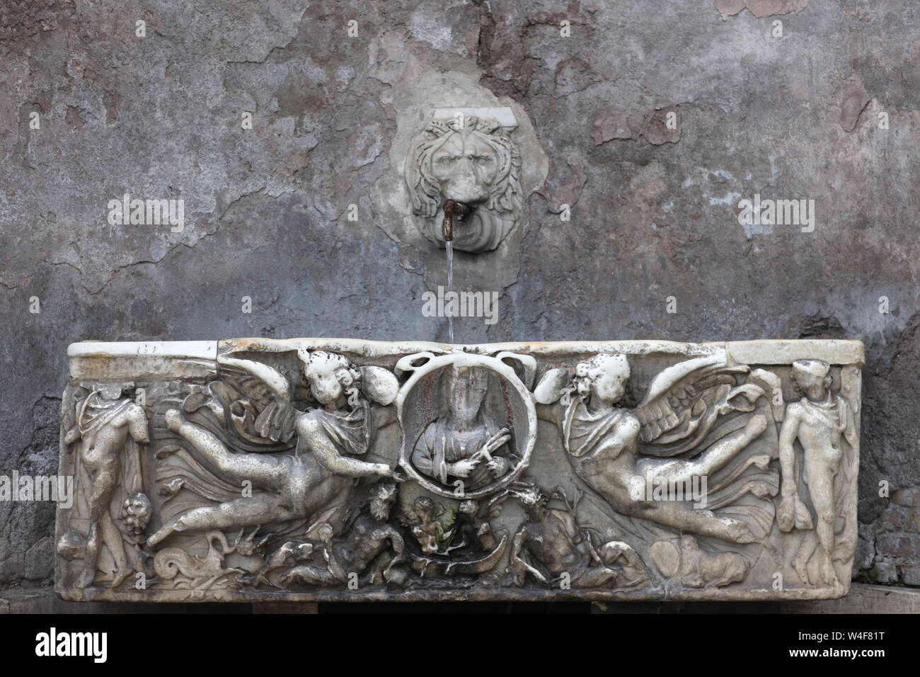 Source of water in the form of a lion's head and a bas-relief with a ...