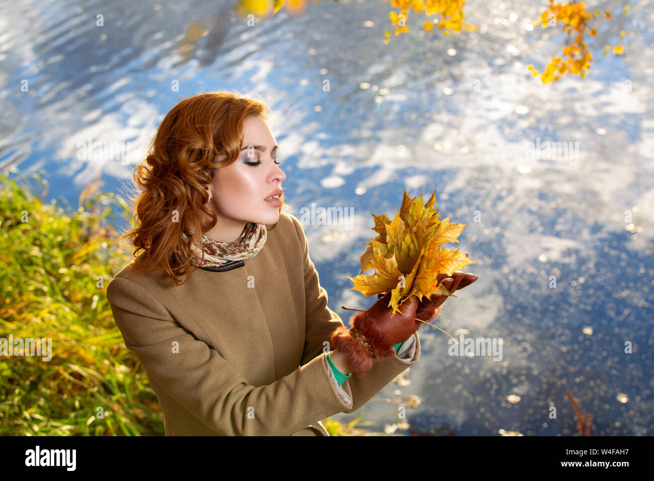 Young woman in the park and holds yellow autumn maple leaves Stock ...