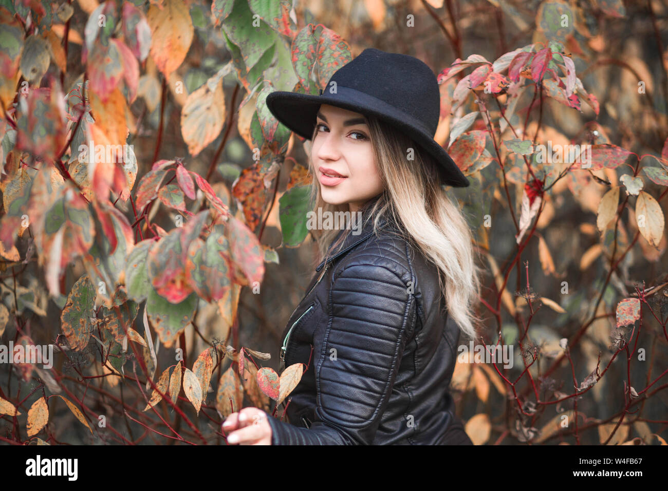 photo of Beautiful girl in a red dress and black jacket posing against ...
