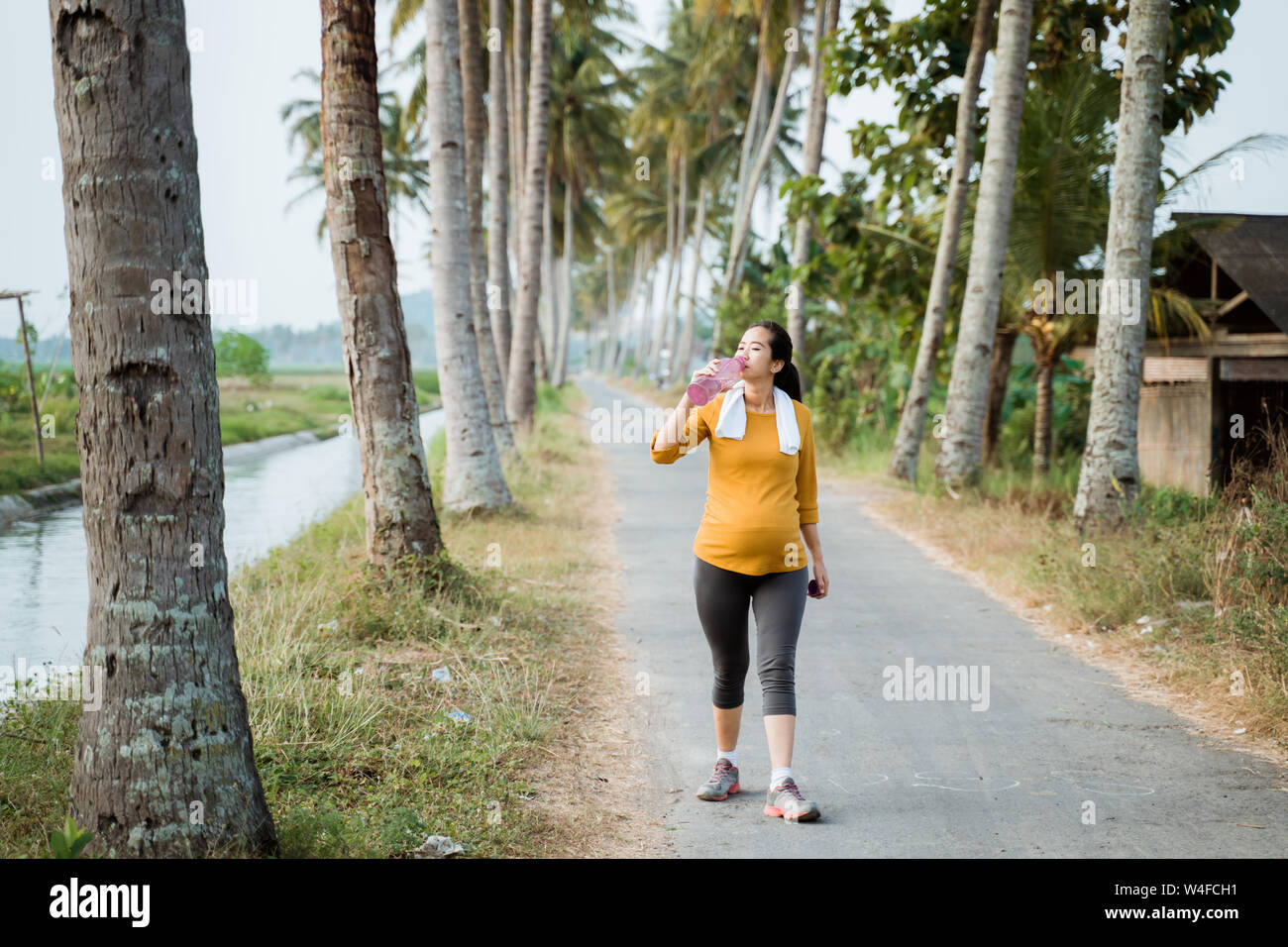 pregnant woman drink water bottle while workout Stock Photo Alamy