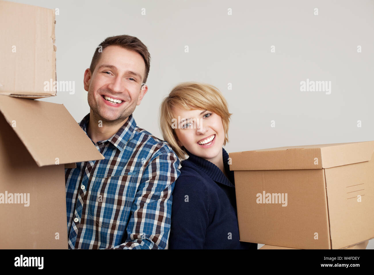 Happy couple in new home holding boxes Stock Photo - Alamy