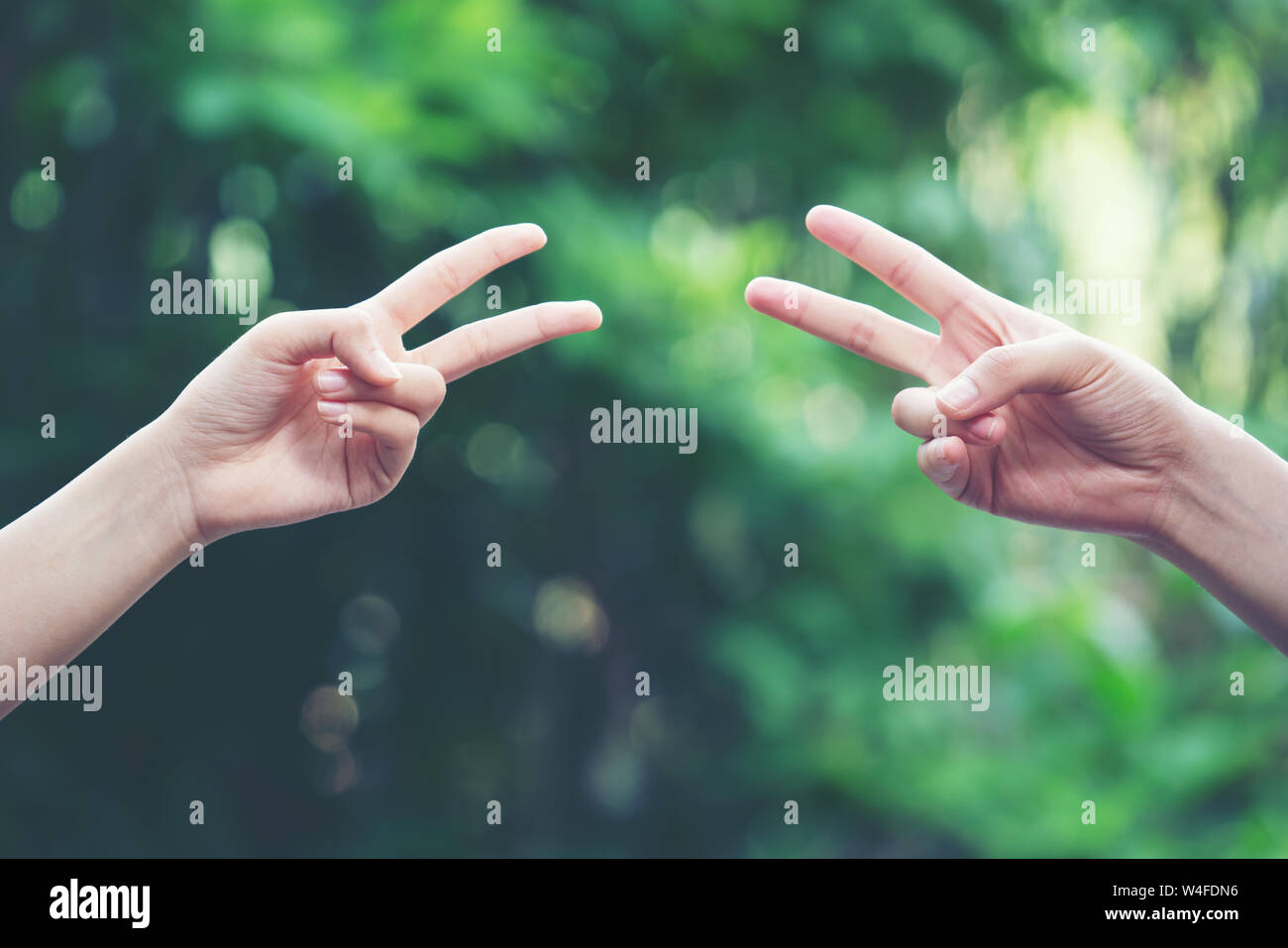 Couple play rock paper scissors hand game nature green background Stock Photo