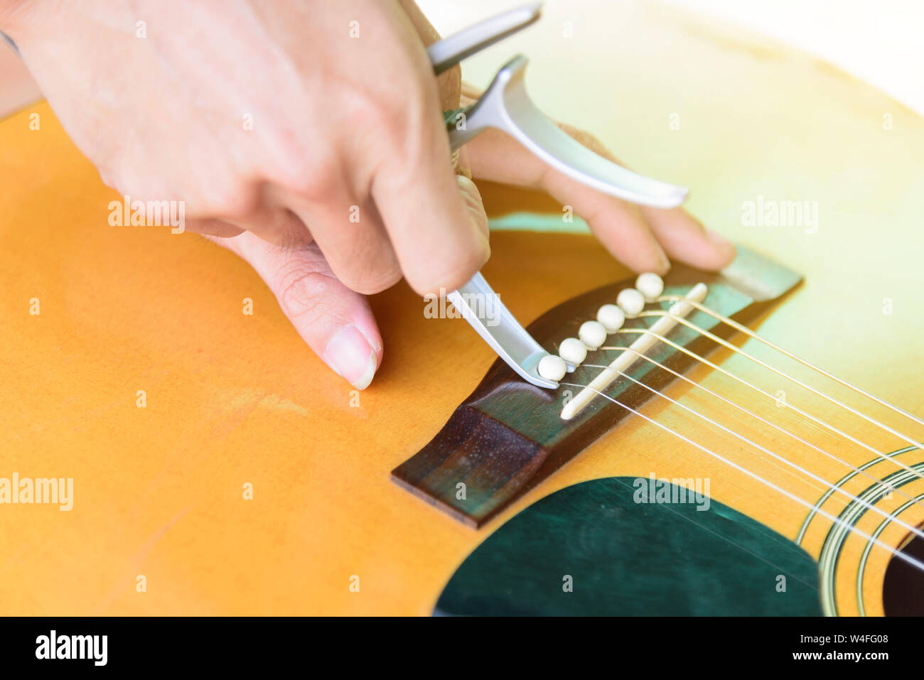 Remove acoustic guitar bridge pin by capo options Stock Photo ...