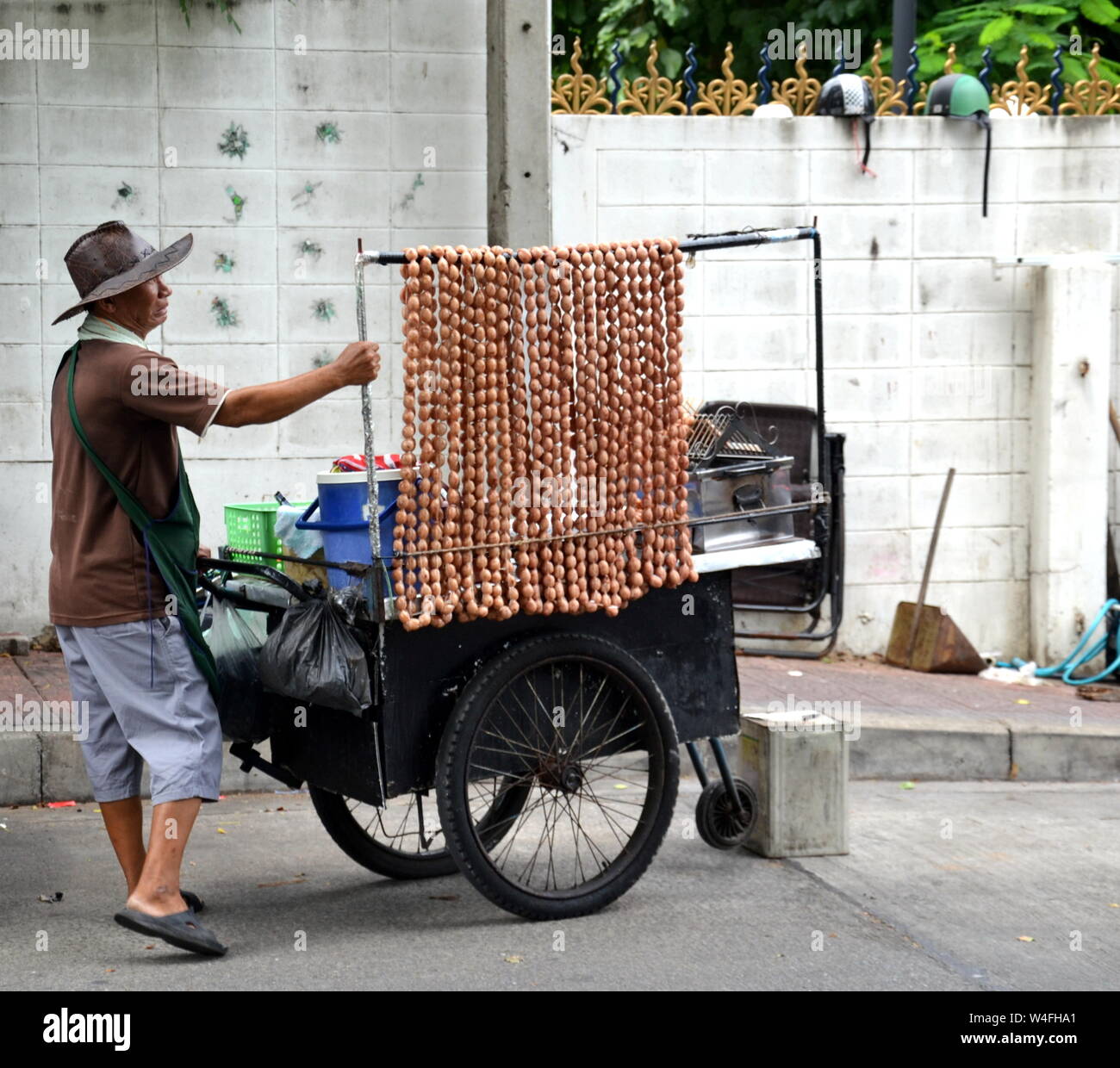 A street food seller in Bangkok, Thailand, Asia, wheels his mobile cart