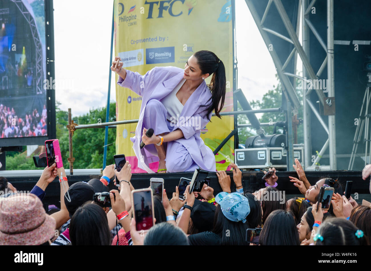 Pia Wurtzbach, a Filipino celebrity and former Miss Universe poses for a selfie with fans while performing on stage at a cultural event in London. Stock Photo