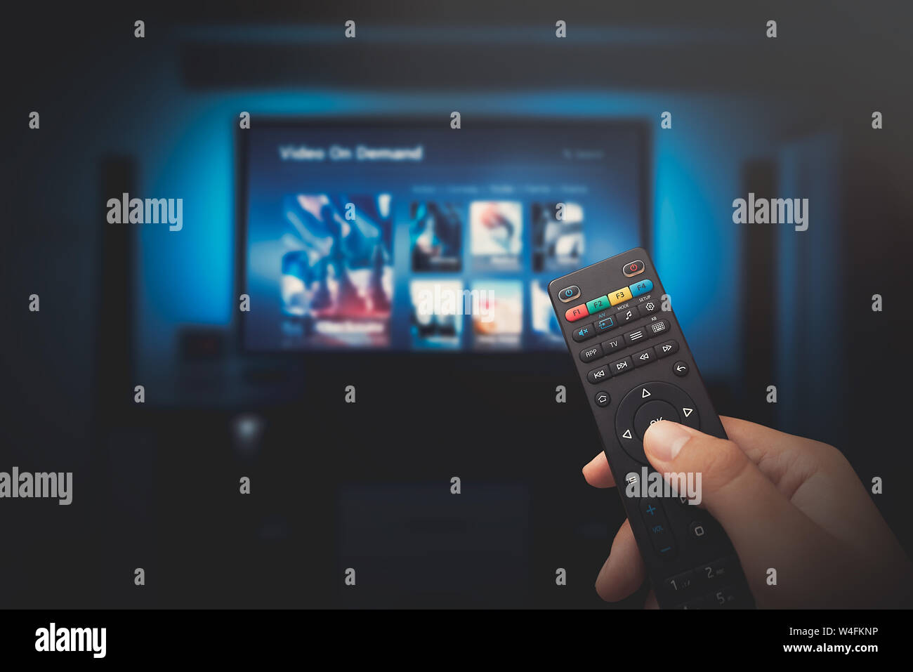 VOD service screen. Man watching TV with remote control in hand. Stock Photo