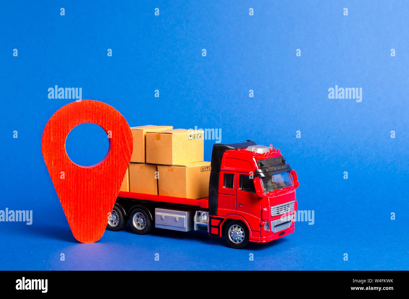 A red truck loaded with boxes and a red pointer location. Services transportation of goods, products, logistics and infrastructure. Transportation com Stock Photo