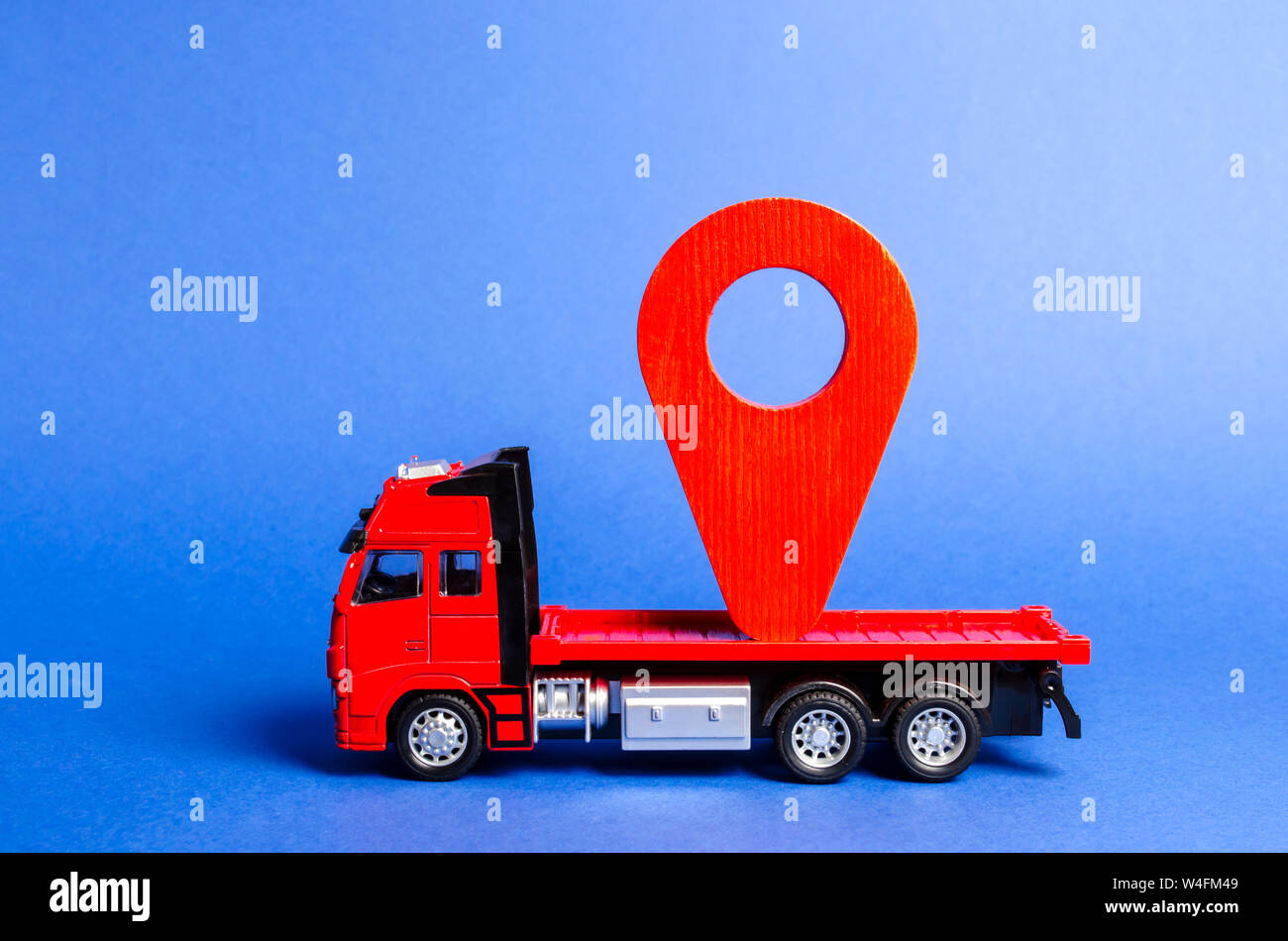 Red truck carries a red pointer location. Services transportation of goods and products, logistics and infrastructure. Transportation company Warehous Stock Photo
